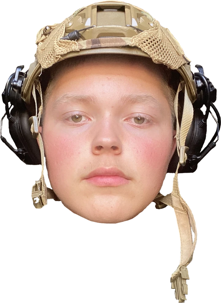 Liam wearing a tan helmet and headset.